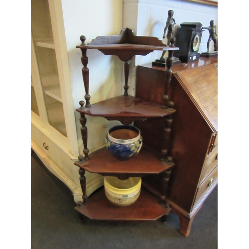 1023 - An Edwardian walnut four tier corner Wotnot, spindle supports, 125cm tall