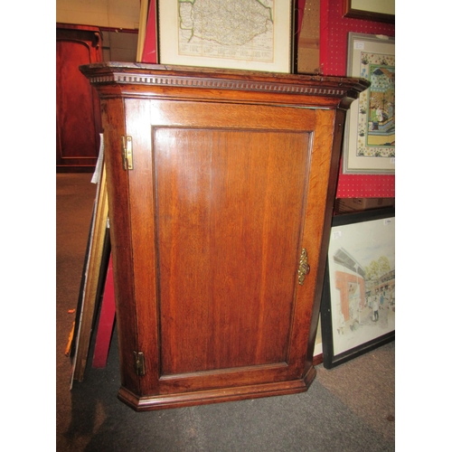 1061 - A Georgian oak corner cupboard, with key, 92cm tall