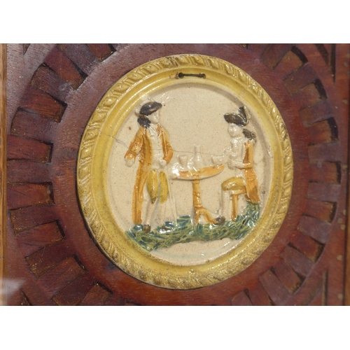 4328 - An early 19th Century Prattware plaque moulded in relief depicting a seated and standing gentleman a... 