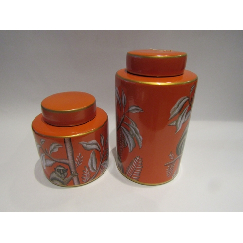 4339 - A graduated pair of jars with covers, orange ground printed with monkeys in trees, 26cm and 16cm tal... 