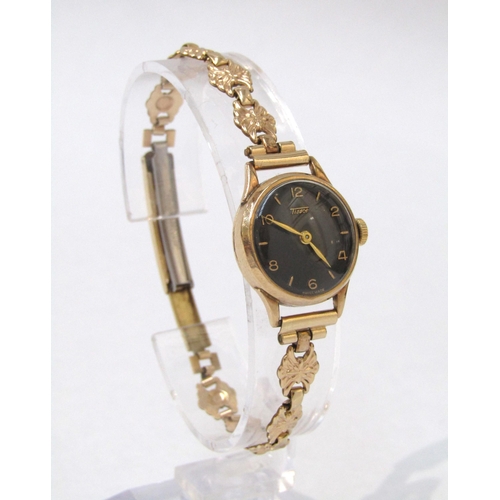 8186 - TISSOT: A 9ct gold case Tissot lady's wristwatch, black dial with Arabic numerals, 14g total weight