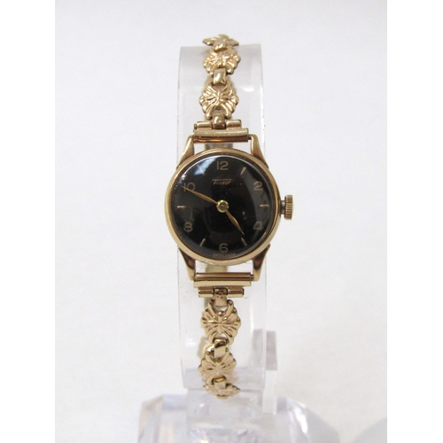 8186 - TISSOT: A 9ct gold case Tissot lady's wristwatch, black dial with Arabic numerals, 14g total weight