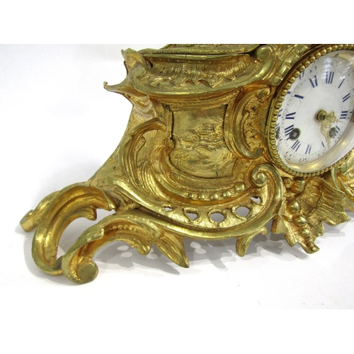 8063 - A 19th Century French gilt metal mantel clock, scroll and shell form design with white enamel and bl... 