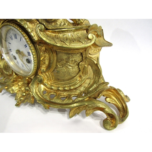 8063 - A 19th Century French gilt metal mantel clock, scroll and shell form design with white enamel and bl... 