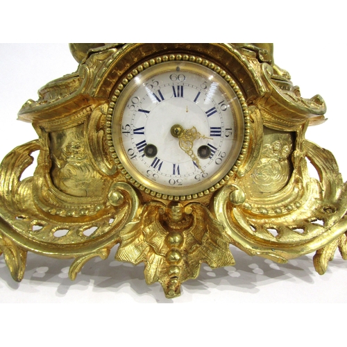 8063 - A 19th Century French gilt metal mantel clock, scroll and shell form design with white enamel and bl... 