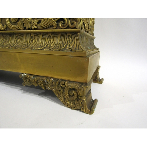 8043 - A large 19th Century gilt metal mantel clock, he ornate scroll design base surmounted by a distingui... 