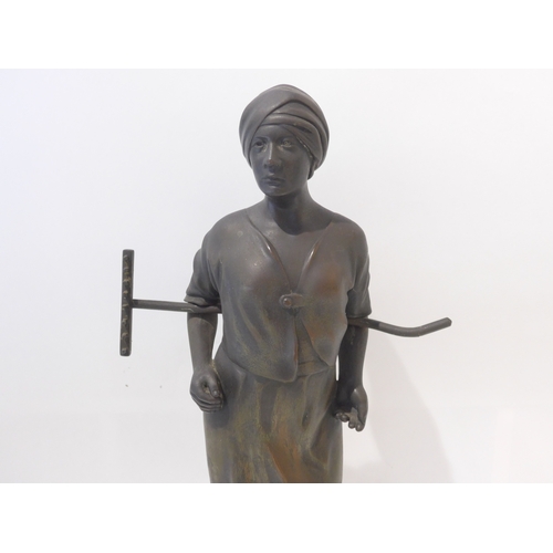 6103 - A 19th Century bronze of a field girl in the style of Millet, standing holding a rake behind her bac... 