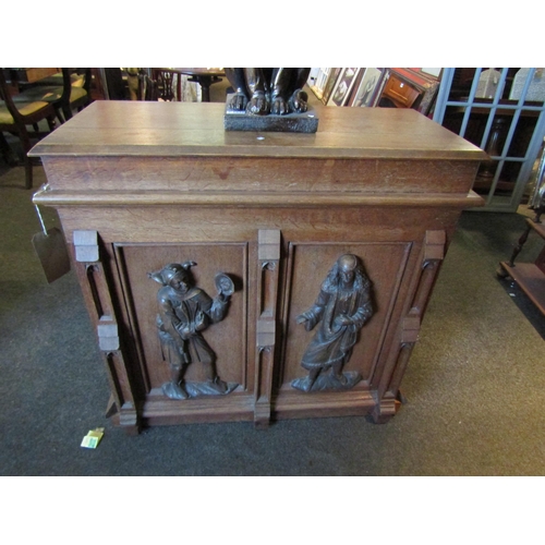 1030 - A late 19th Century oak shop counter, heavily carved figures to front section, linen fold door to si... 