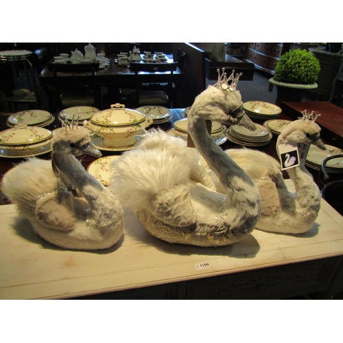 1103 - A faux feathered white swan wearing a crown, 49cm tall, two smaller examples and a flamingo (4)