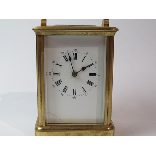 8103 - A brass cased carriage timepiece, with twin barrel movement striking on a gong and gilt coloured pla... 