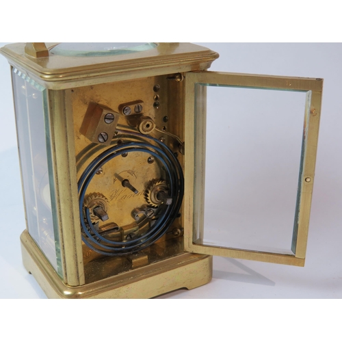 8103 - A brass cased carriage timepiece, with twin barrel movement striking on a gong and gilt coloured pla... 