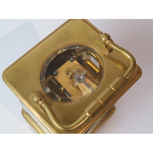 8103 - A brass cased carriage timepiece, with twin barrel movement striking on a gong and gilt coloured pla... 