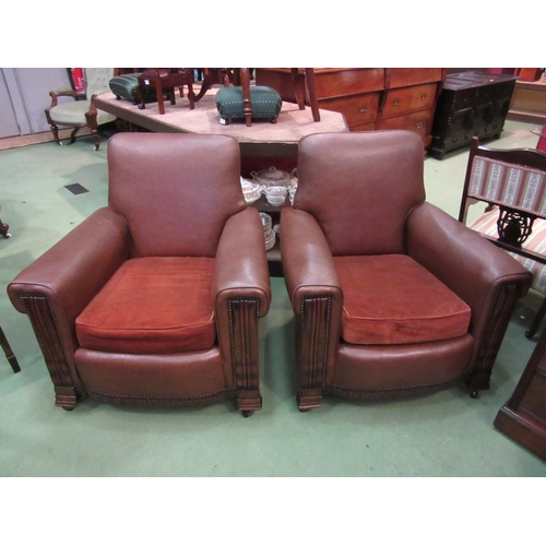 4129 - A pair of Art Deco club armchairs with carved oak fascia and brass stud decoration on later castors