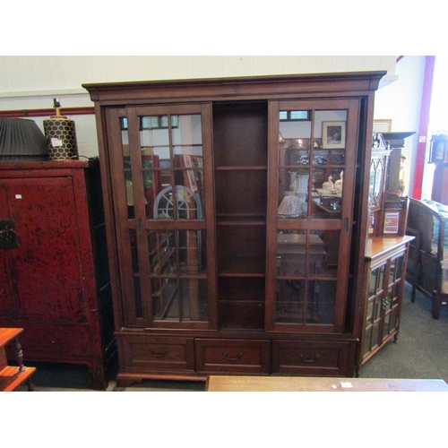 1015 - A full height display cabinet, sliding doors, on three drawer base, repair to back, 215cm tall x 180... 