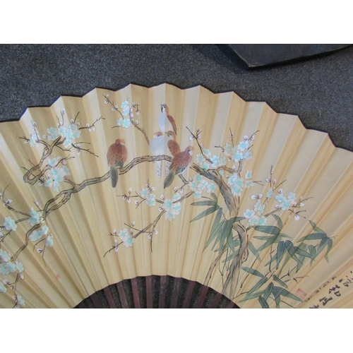 1027 - A large Oriental fan with scenes of birds in trees