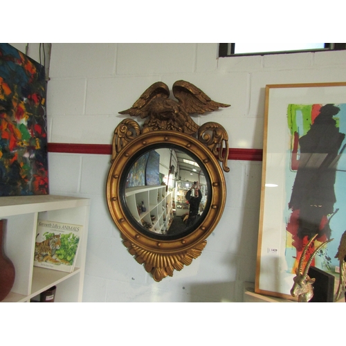 1438 - A Regency style gilt convex wall mirror, surmounted with carved wooden eagle, 100cm tall x 60cm wide