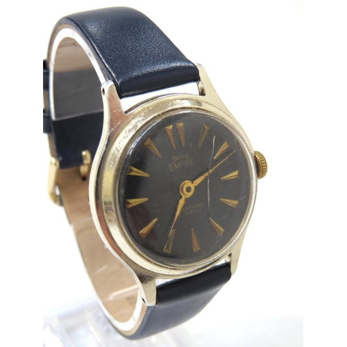 8176 - A Smiths Empire black dial gentleman's wristwatch, blue engine turned dial with gilt arrow markers i... 