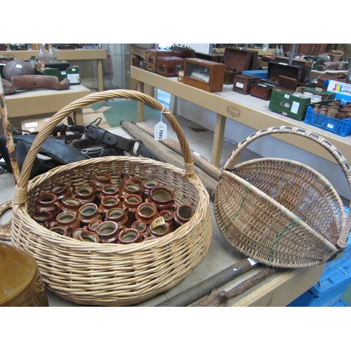 7092 - A wicker basket containing single handled jam pots