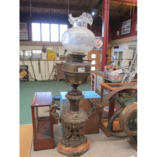 7289 - A decorative brass oil lamp base with elaborate swan detail and decorative glass shade