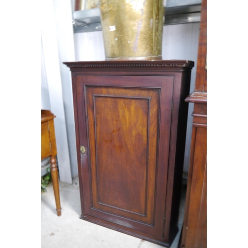 3323 - A Georgian mahogany corner cupboard with brass cherub lock plate with key