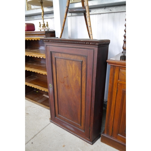 3323 - A Georgian mahogany corner cupboard with brass cherub lock plate with key