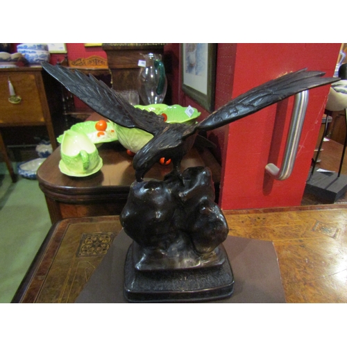 4030 - A Japanese bronze figure of eagle perched on rock, 25cm tall