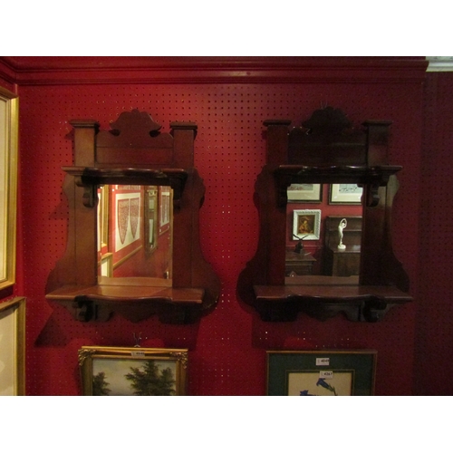 4047 - A pair of mahogany wall mirrors with shelves and shaped design, one with original bevelled glass, 60... 