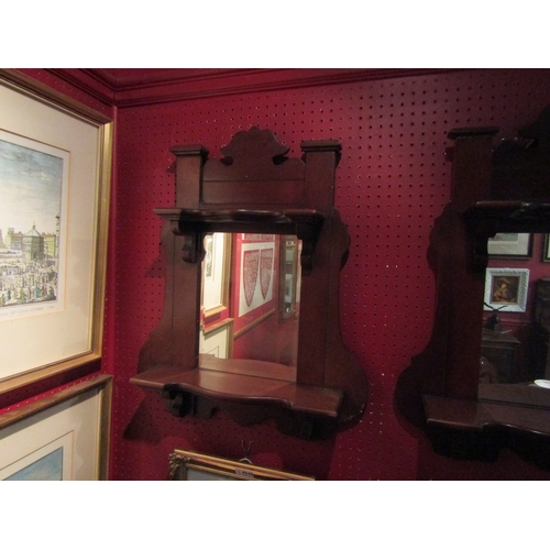 4047 - A pair of mahogany wall mirrors with shelves and shaped design, one with original bevelled glass, 60... 