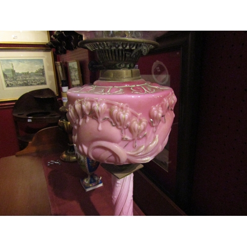 4055 - A Victorian oil lamp, pink glass bleeding heart reservoir, turned column and cranberry shade