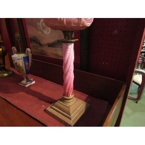 4055 - A Victorian oil lamp, pink glass bleeding heart reservoir, turned column and cranberry shade