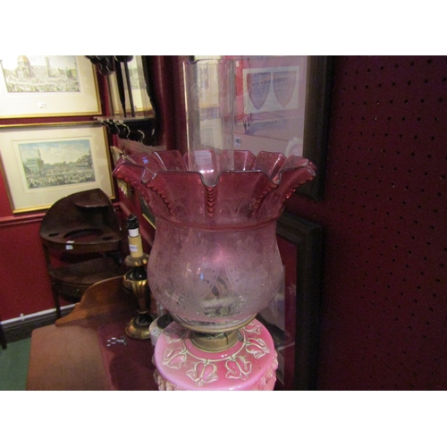 4055 - A Victorian oil lamp, pink glass bleeding heart reservoir, turned column and cranberry shade