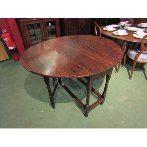 4063 - A Circa 1800 oval top pegged oak gateleg table the rising leaves over a single cutlery drawer on tur... 