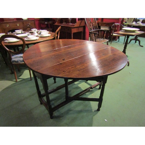 4063 - A Circa 1800 oval top pegged oak gateleg table the rising leaves over a single cutlery drawer on tur... 