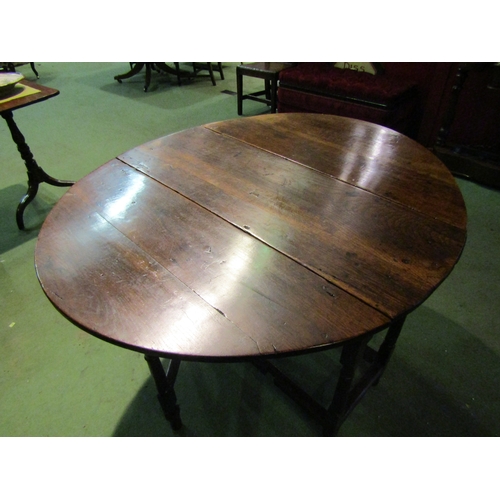 4063 - A Circa 1800 oval top pegged oak gateleg table the rising leaves over a single cutlery drawer on tur... 