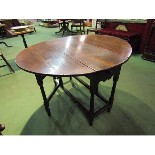 4063 - A Circa 1800 oval top pegged oak gateleg table the rising leaves over a single cutlery drawer on tur... 