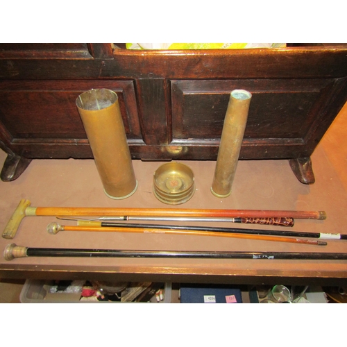 4194 - Three brass shell cases, one converted into an ashtray, together with a quantity of walking sticks a... 