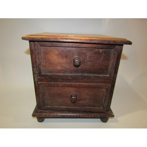 4266 - An oak miniature chest of two drawers, 26cm tall x 22cm x 21cm