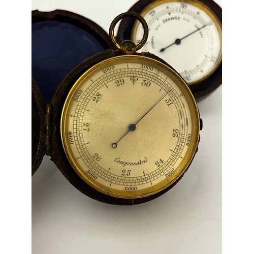 5184 - Two 19th Century gilt brass cased pocket barometers each housed within leather cases, one with silve... 