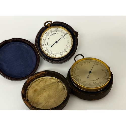 5184 - Two 19th Century gilt brass cased pocket barometers each housed within leather cases, one with silve... 