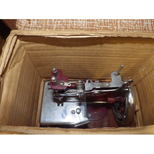 2060 - A child's miniature sewing machine in original carrying case