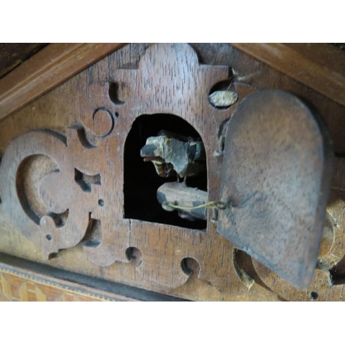 8021 - A 19th Century German walnut and parquetry inlaid cuckoo clock, with pendulum