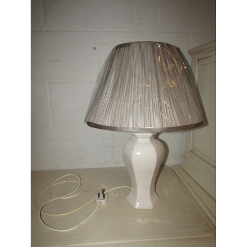 1025 - A brown ribbed table lamp with cream pleated shade and a white glazed ceramic table lamp with grey s... 