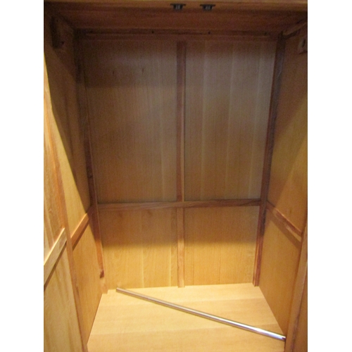 1083 - A light oak wardrobe, two doors over single drawer base, 185cm tall x 104cm wide x 52cm deep