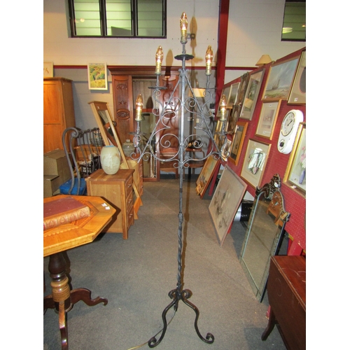 1110 - A wrought iron tiered standard lamp on scrolled tripod feet, 73cm tall