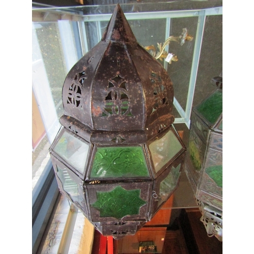 1001 - Two Moorish lantern cases with green moulded and clear glass panes, one pane a/f. 55cm and 60cm drop