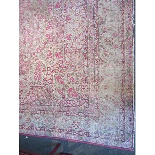 1480 - A Persian pink and cream ground rug with central floral panel, multiple borders, very worn, 380cm x ... 