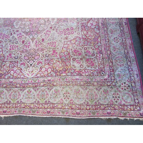 1480 - A Persian pink and cream ground rug with central floral panel, multiple borders, very worn, 380cm x ... 