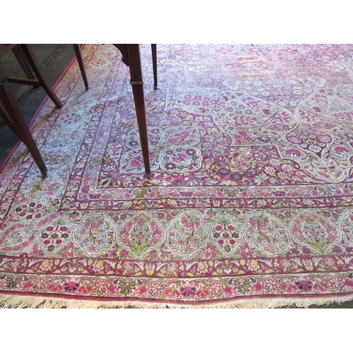 1480 - A Persian pink and cream ground rug with central floral panel, multiple borders, very worn, 380cm x ... 