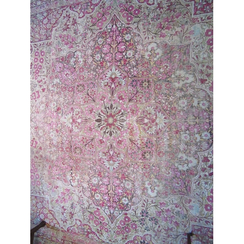 1480 - A Persian pink and cream ground rug with central floral panel, multiple borders, very worn, 380cm x ... 