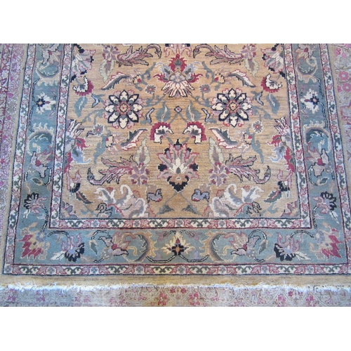 1481 - A Turkish wool rug, gold ground with green border and floral design, 246cm x 152cm